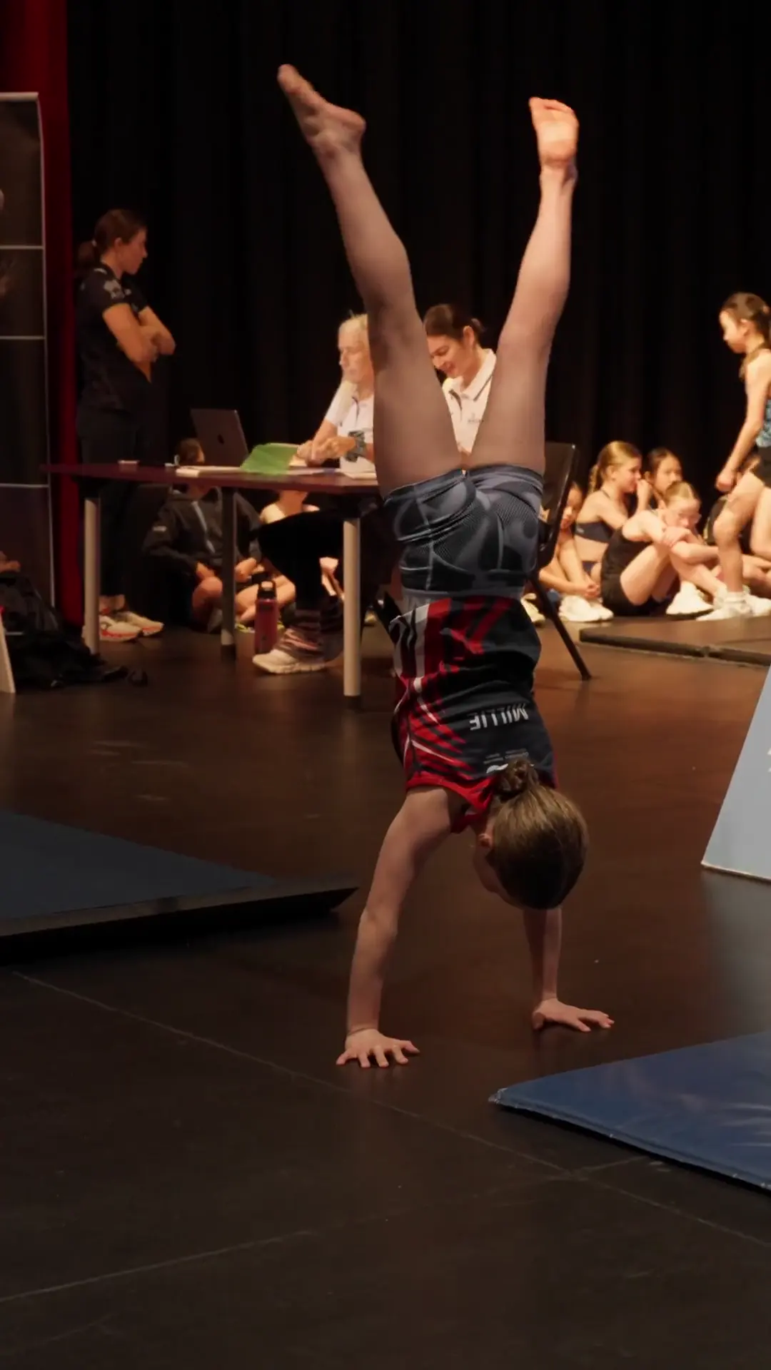 A young athlete holding a handstand at the national diving competition in Adelaide