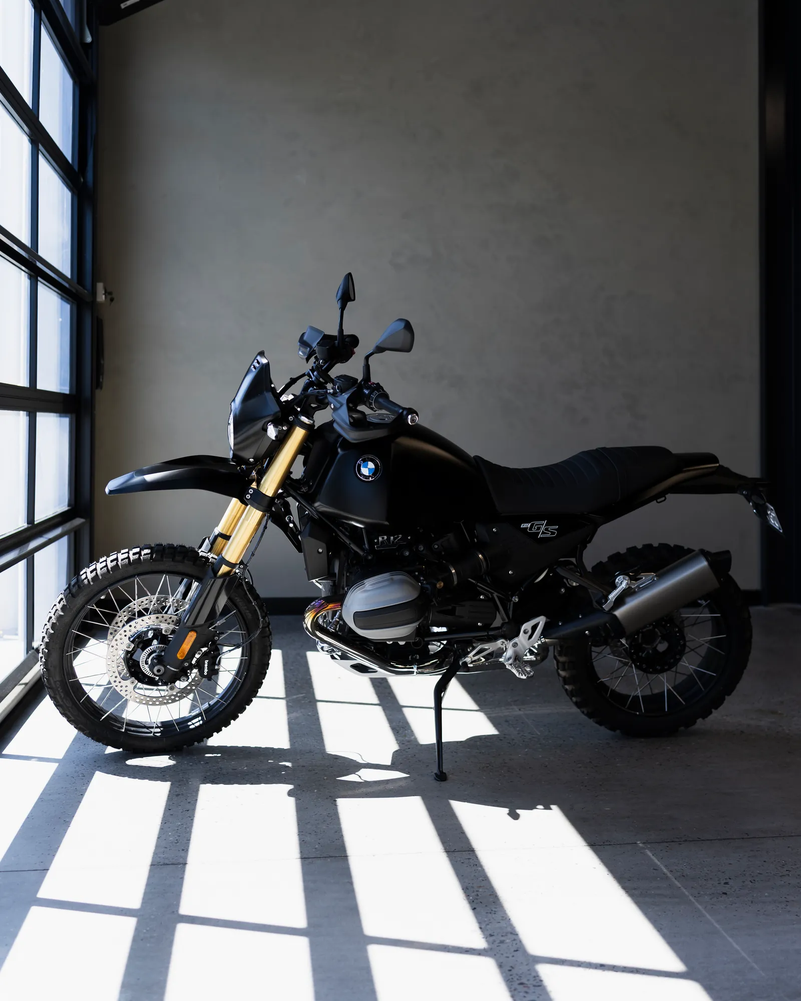 A BMW Motorrad adventure bike indoors in hard window light