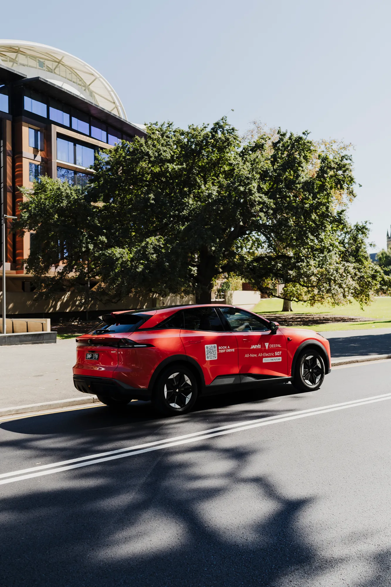 A red Deepal EV on the road beside Adelaide Oval