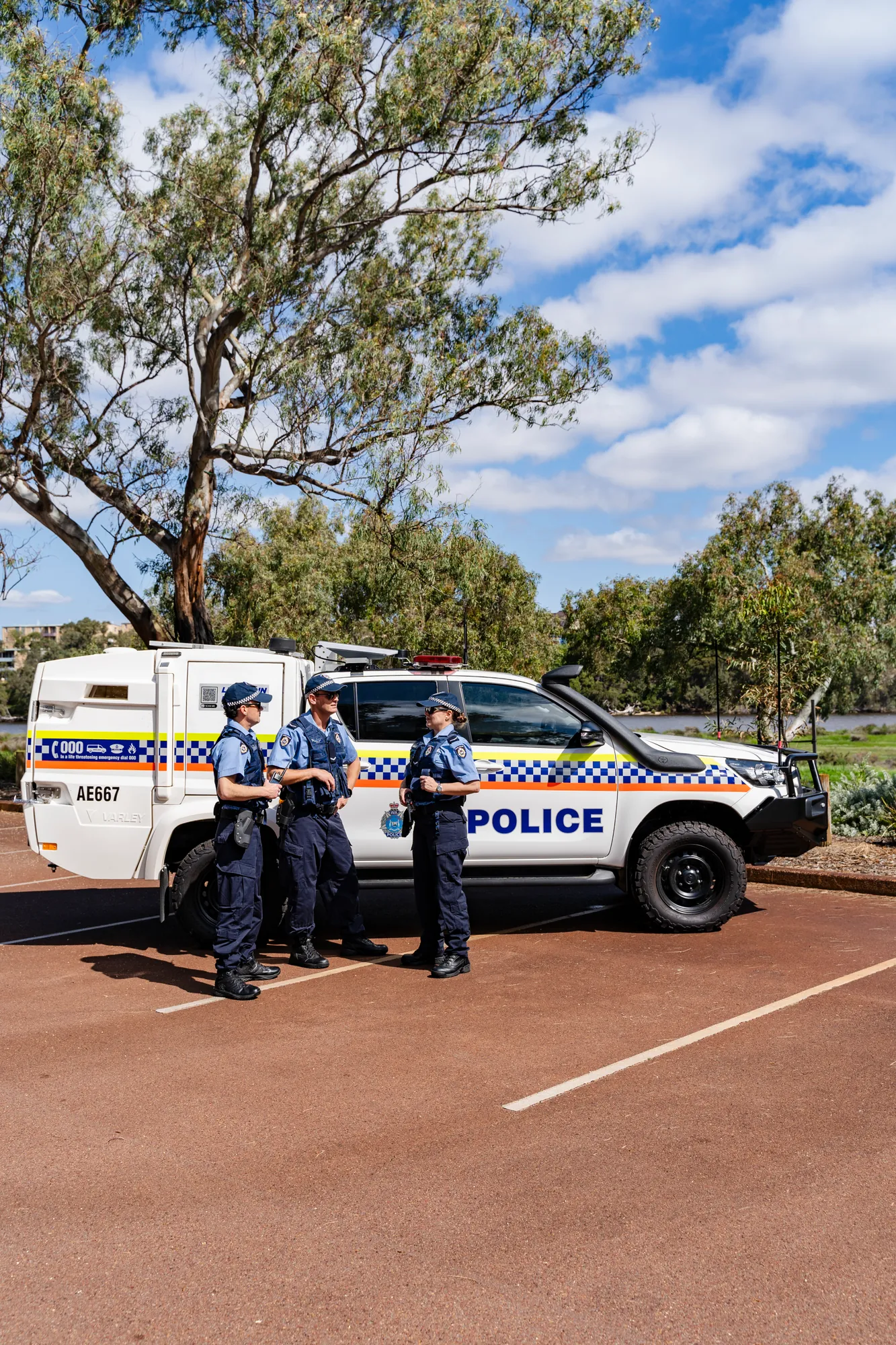 Officers beside a marked police four-wheel drive on a coastal path
