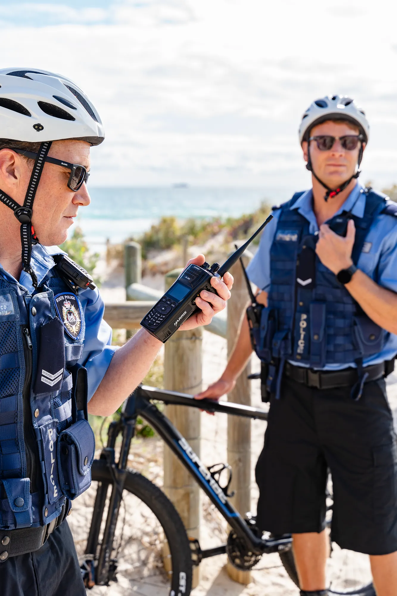 Two bicycle officers with L3Harris radios mounted on their vests