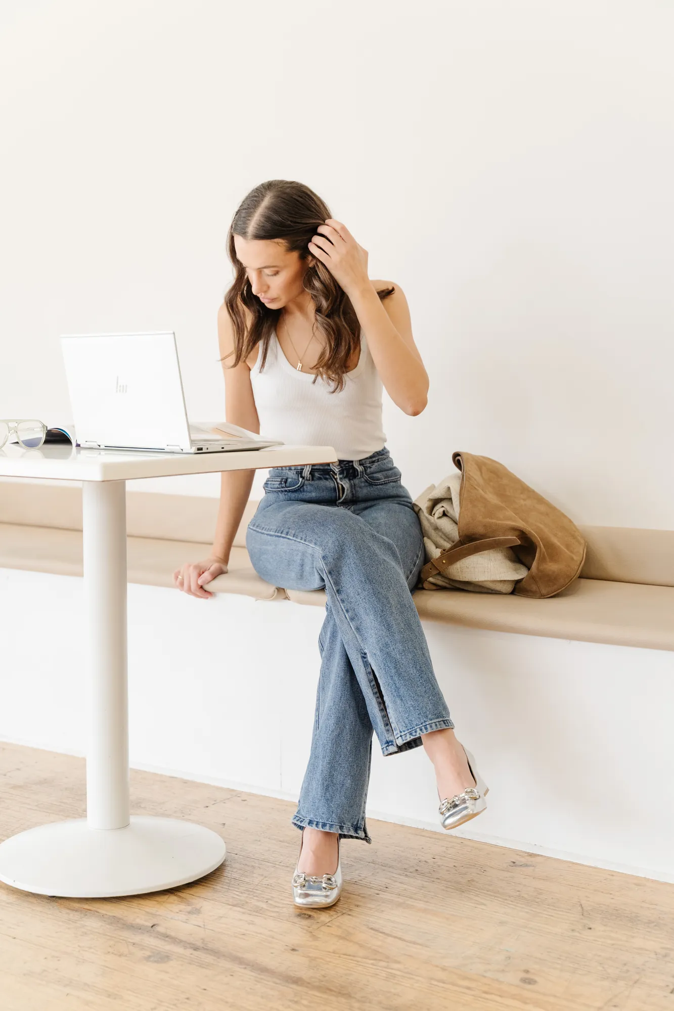 Penn Shoes campaign: white top, jeans and silver heels at a cafe table